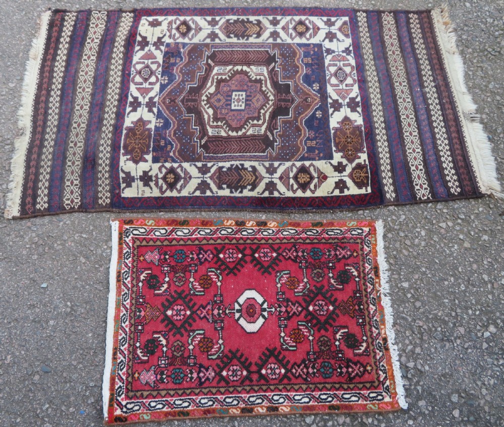 A pair of hand-woven tribal wool rugs featuring geometric medallions in tones of red, blue, brown, and cream with fringed edges. View II