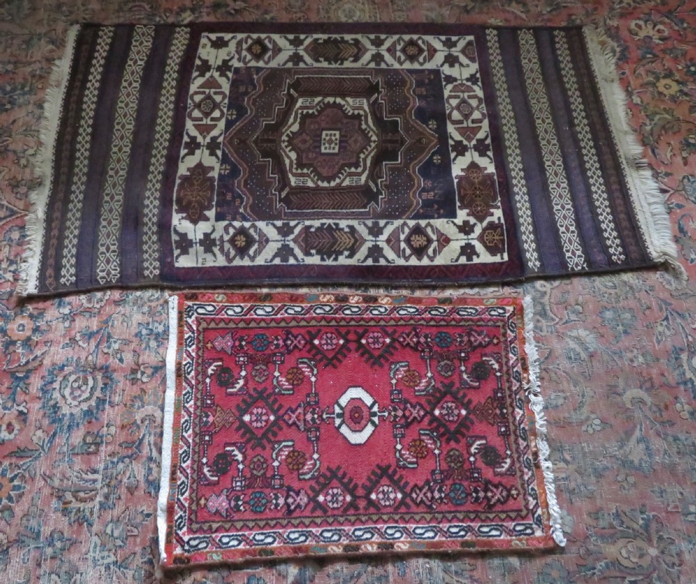 A pair of hand-woven tribal wool rugs featuring geometric medallions in tones of red, blue, brown, and cream with fringed edges. View XIV
