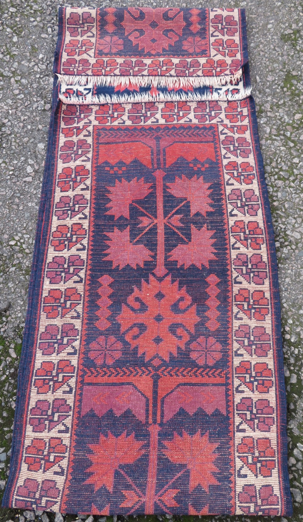 A long, narrow hand-knotted Turkish Yagjibedir runner rug featuring geometric tribal motifs in deep red against a dark navy blue background with a patterned ivory border. View VI