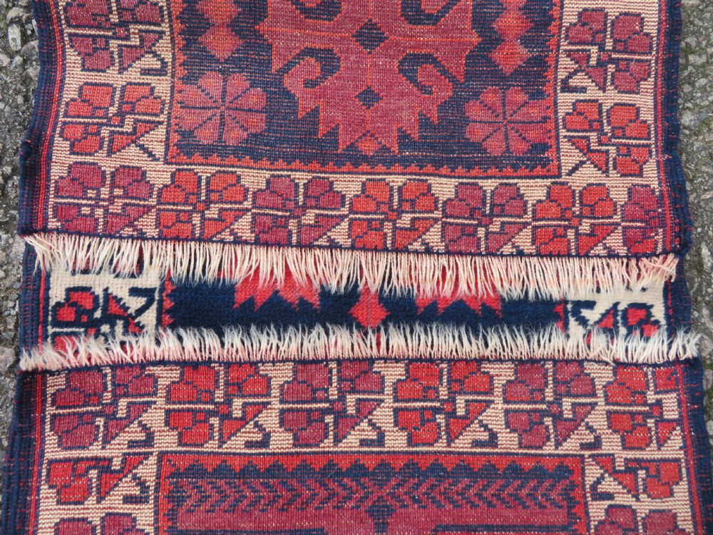 A long, narrow hand-knotted Turkish Yagjibedir runner rug featuring geometric tribal motifs in deep red against a dark navy blue background with a patterned ivory border. View VIII