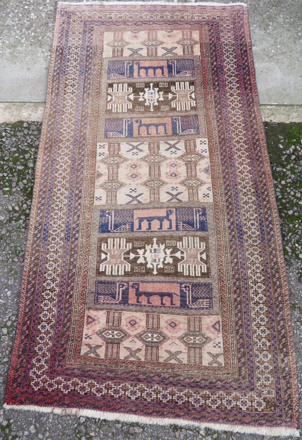 A hand-knotted Afghan wool rug featuring panelled sections with stylized animal motifs and geometric borders in terracotta, beige, brown, and navy blue hues.