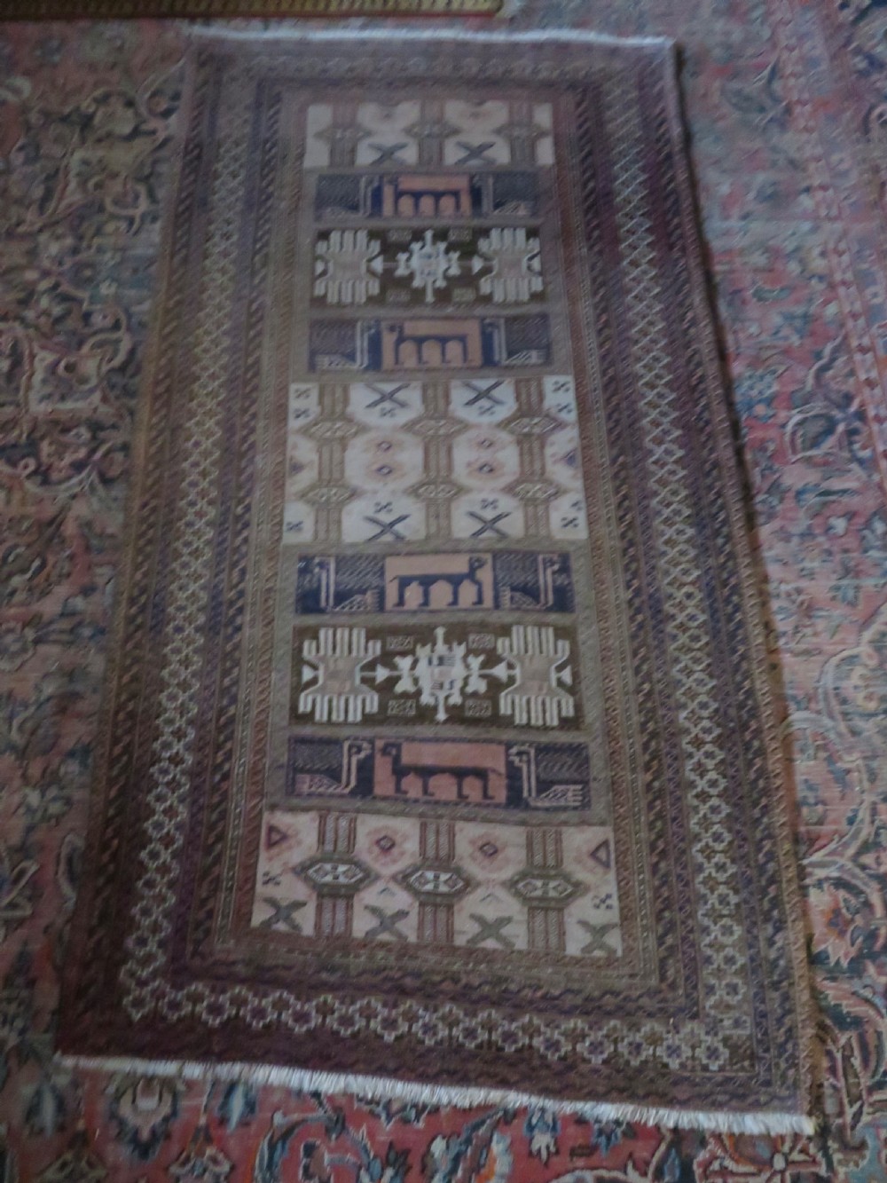 A hand-knotted Afghan wool rug featuring panelled sections with stylized animal motifs and geometric borders in terracotta, beige, brown, and navy blue hues. View III