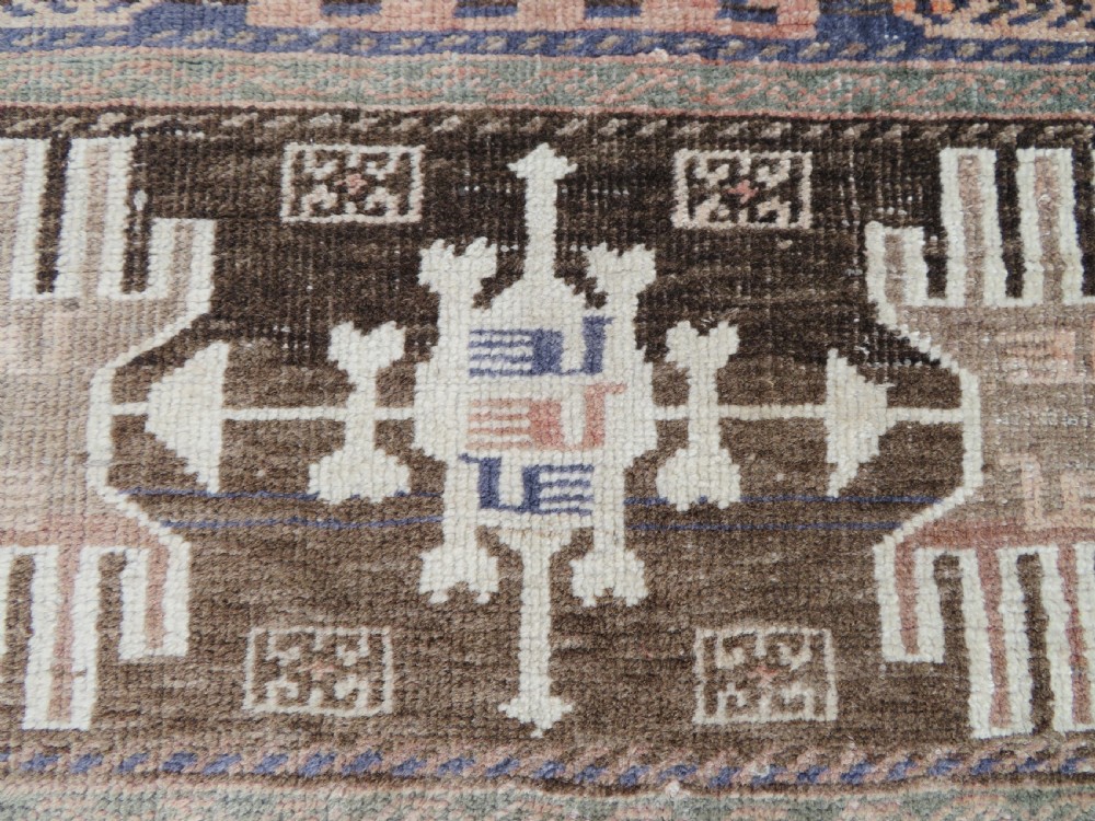 A hand-knotted Afghan wool rug featuring panelled sections with stylized animal motifs and geometric borders in terracotta, beige, brown, and navy blue hues. View VII