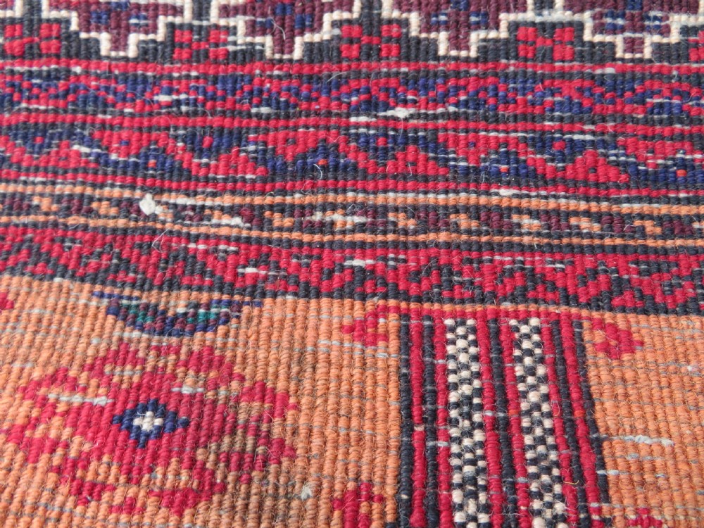 A hand-knotted Afghan wool rug featuring panelled sections with stylized animal motifs and geometric borders in terracotta, beige, brown, and navy blue hues. View XVI
