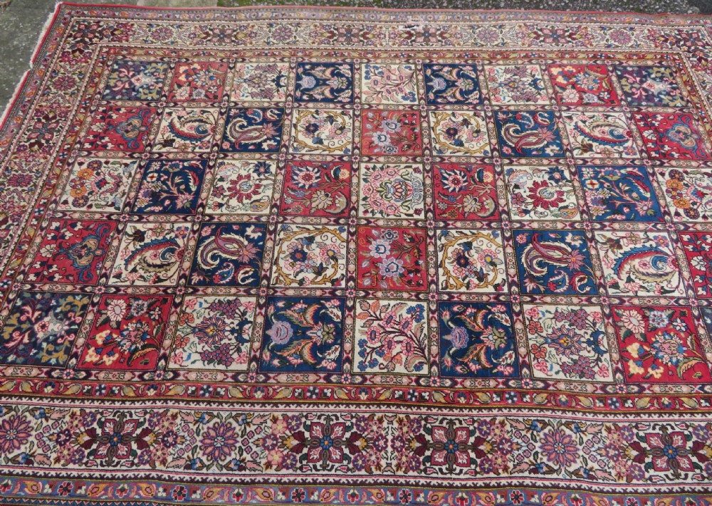 A large hand-knotted Persian Qum carpet with a square compartment panel design featuring floral and boteh motifs in red, blue, and cream enclosed by multi-band borders. View III