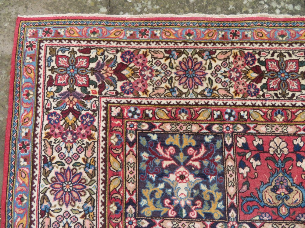A large hand-knotted Persian Qum carpet with a square compartment panel design featuring floral and boteh motifs in red, blue, and cream enclosed by multi-band borders. View VII