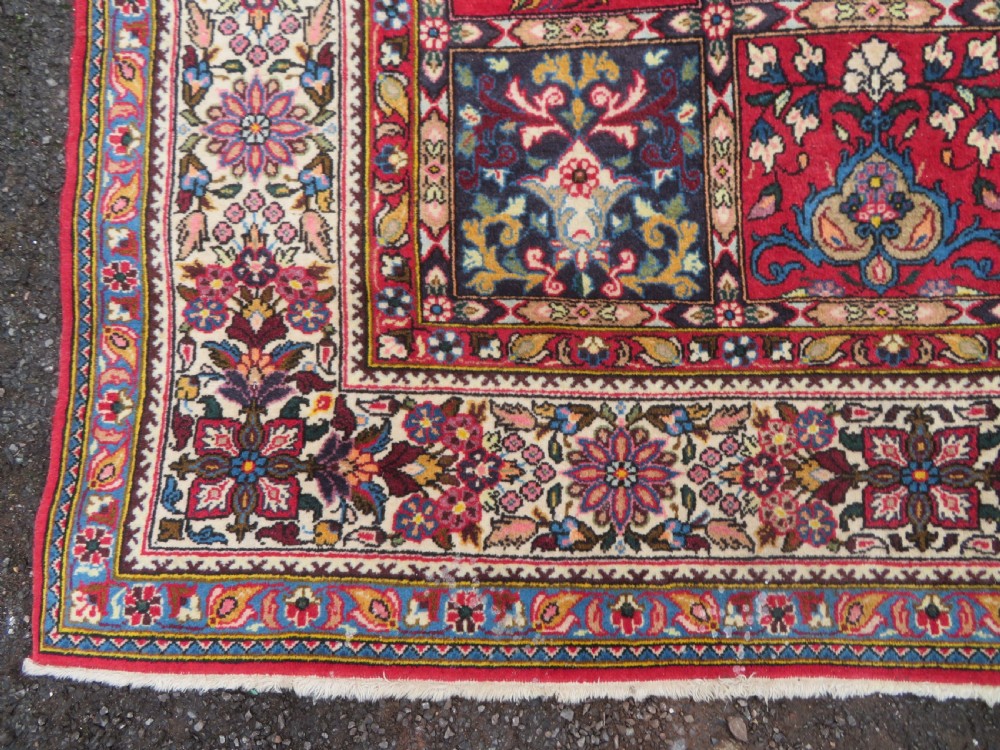A large hand-knotted Persian Qum carpet with a square compartment panel design featuring floral and boteh motifs in red, blue, and cream enclosed by multi-band borders. View XI