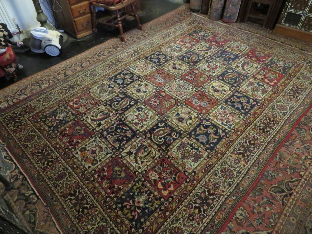 A large hand-knotted Persian Qum carpet with a square compartment panel design featuring floral and boteh motifs in red, blue, and cream enclosed by multi-band borders. View XVIII