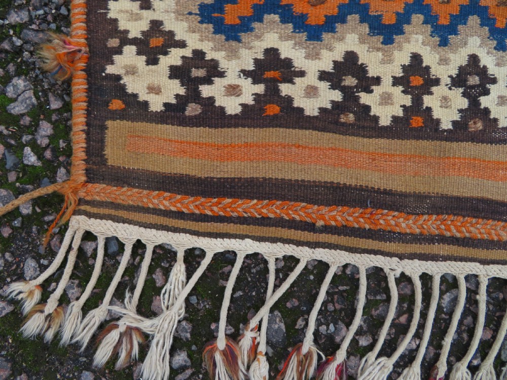 A handwoven Qashqai kilim rug featuring a geometric diamond lattice pattern in terracotta, navy blue, red, and cream with fringed ends. View XIV