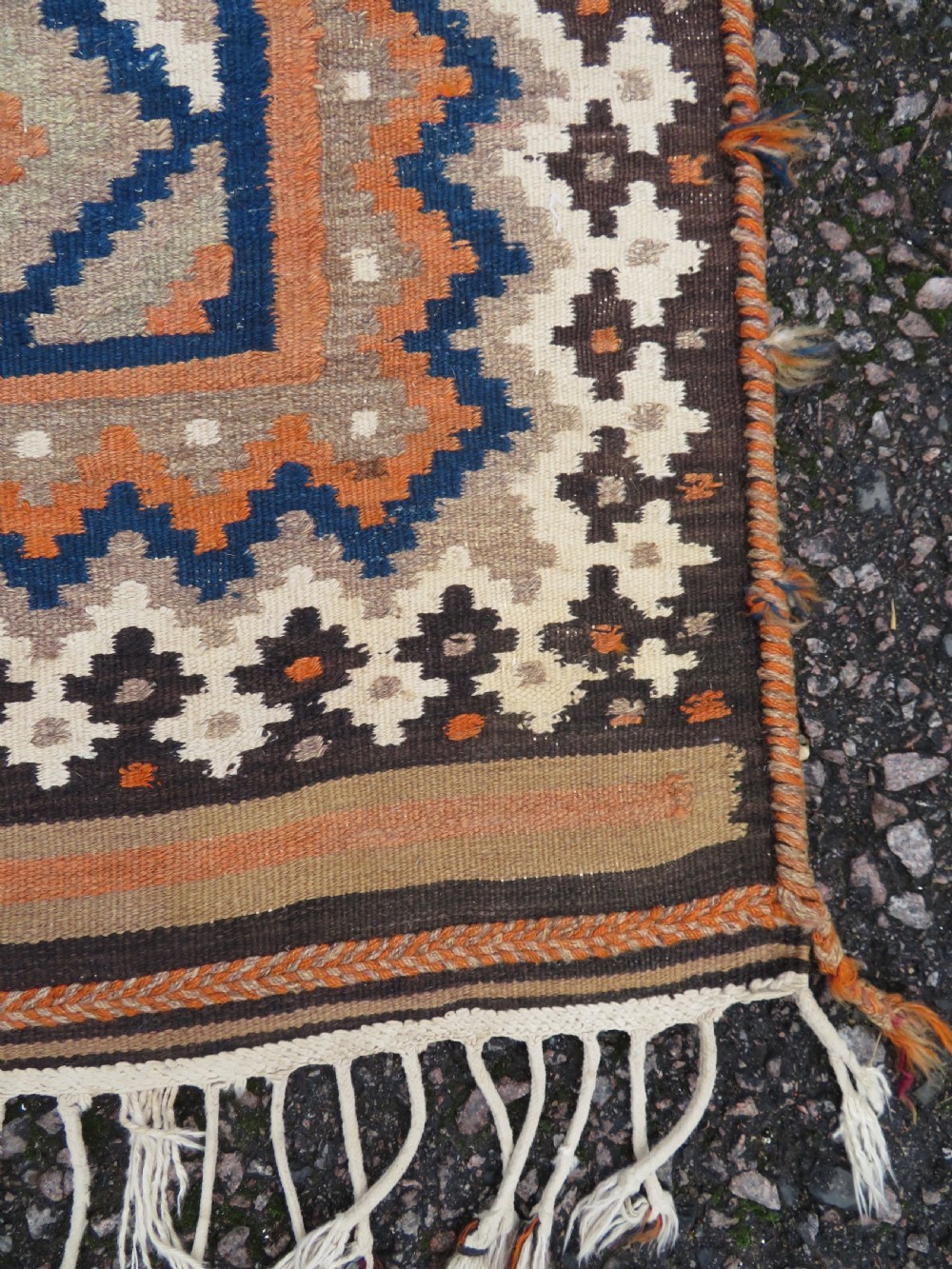 A handwoven Qashqai kilim rug featuring a geometric diamond lattice pattern in terracotta, navy blue, red, and cream with fringed ends. View XV