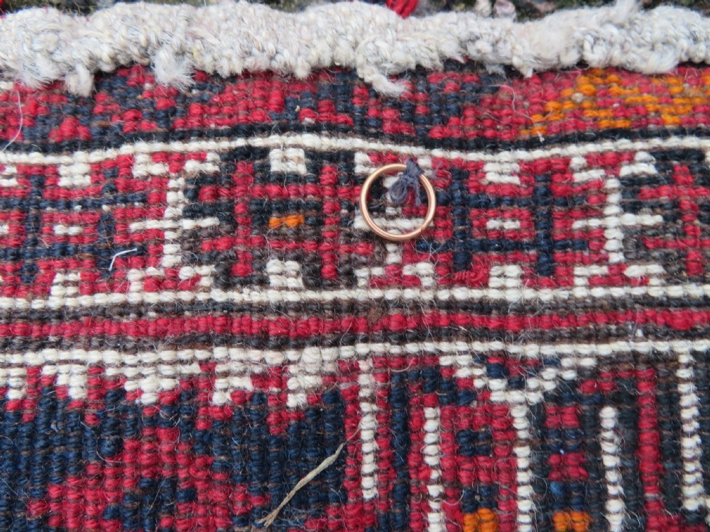 A U-shaped hand-woven Yomut Turkmen kapunuk textile in deep red and dark brown wool with geometric patterns and long hanging tassels along the inner arch. View XIV