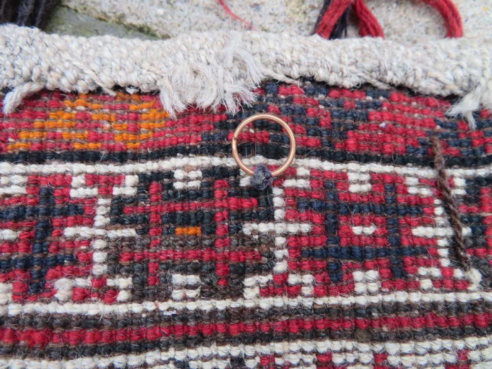 A U-shaped hand-woven Yomut Turkmen kapunuk textile in deep red and dark brown wool with geometric patterns and long hanging tassels along the inner arch. View XV