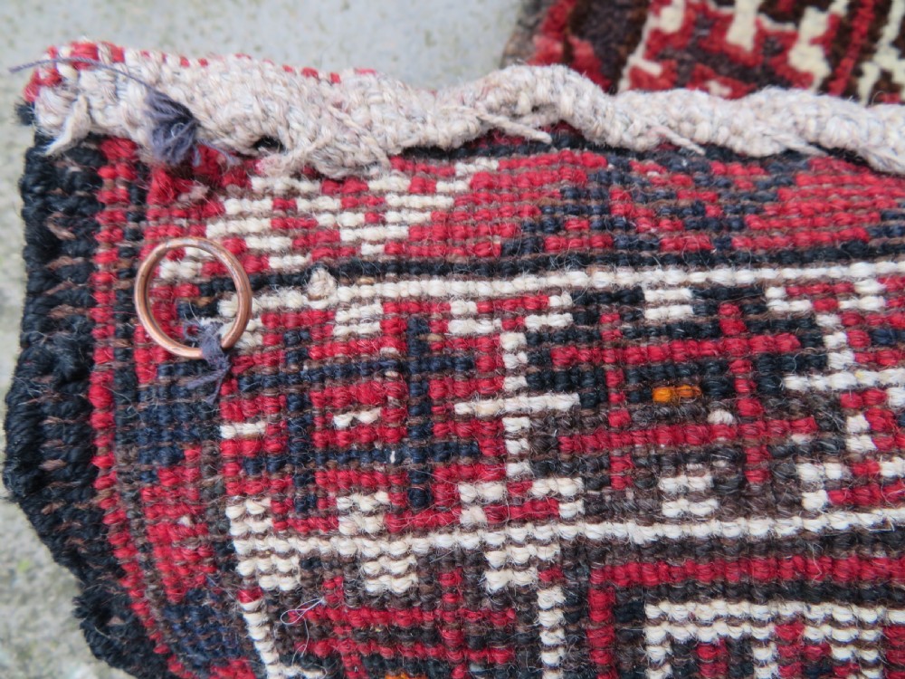 A U-shaped hand-woven Yomut Turkmen kapunuk textile in deep red and dark brown wool with geometric patterns and long hanging tassels along the inner arch. View XVI