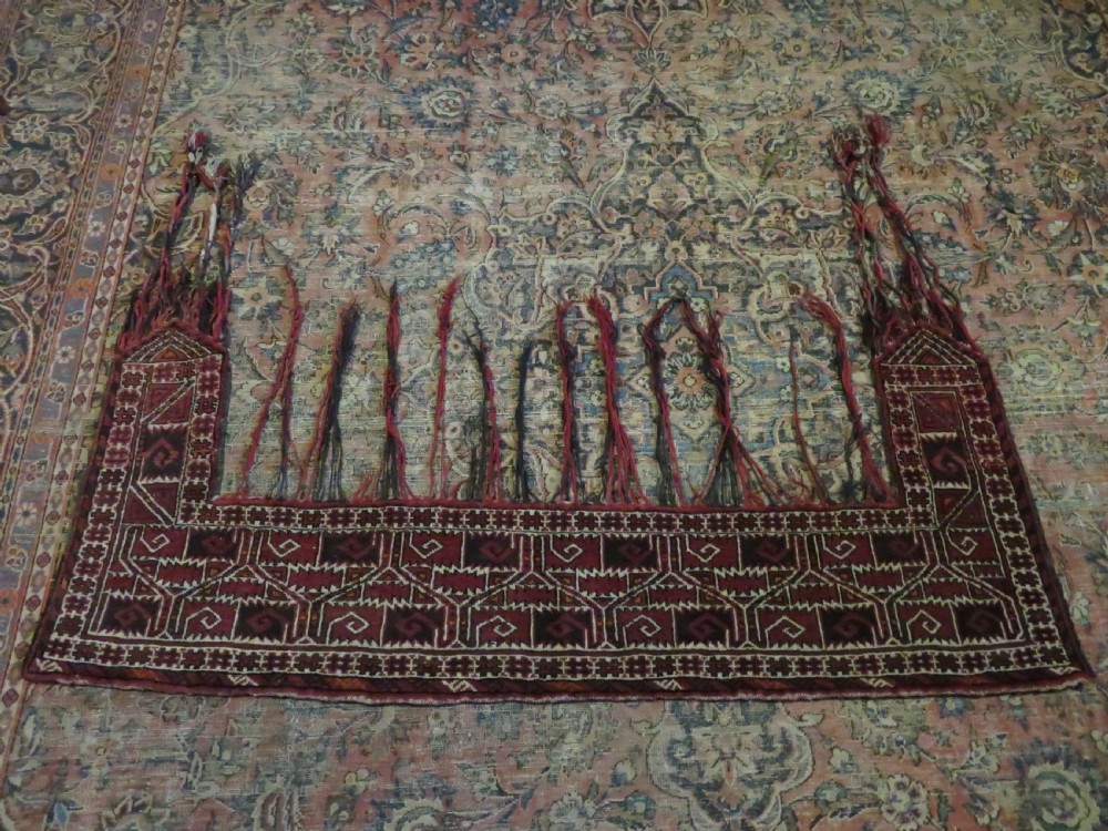 A U-shaped hand-woven Yomut Turkmen kapunuk textile in deep red and dark brown wool with geometric patterns and long hanging tassels along the inner arch. View XVIII