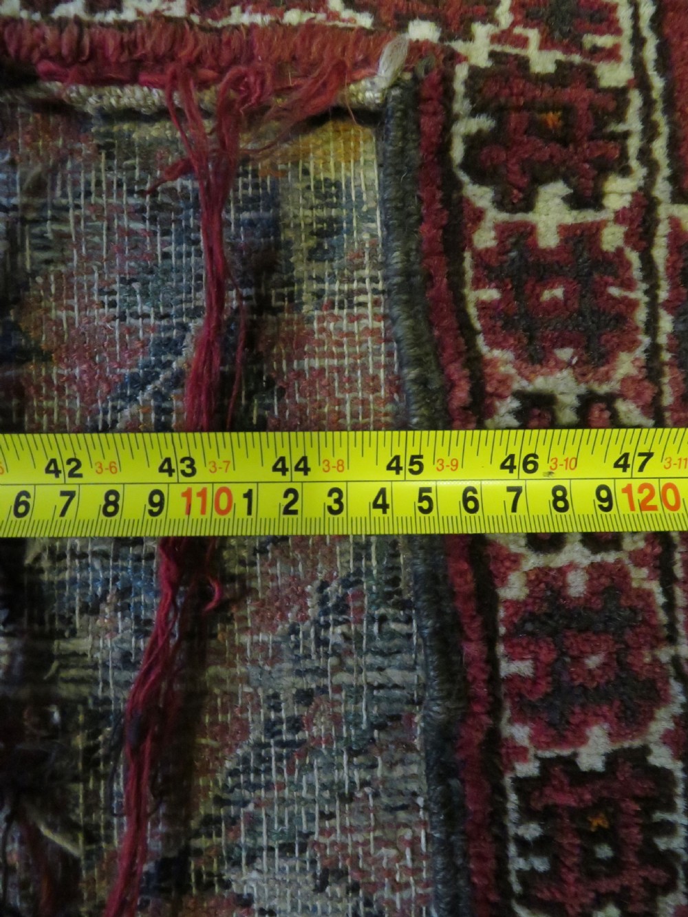 A U-shaped hand-woven Yomut Turkmen kapunuk textile in deep red and dark brown wool with geometric patterns and long hanging tassels along the inner arch. View XX