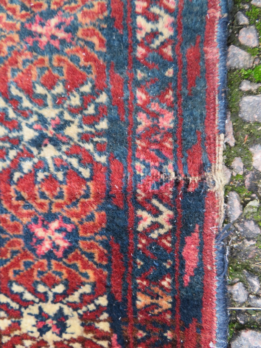 A rectangular hand-knotted Tekke Turkmen wool rug featuring three columns of octagonal gol medallions on a deep red field with geometric borders and fringed ends. View XIV