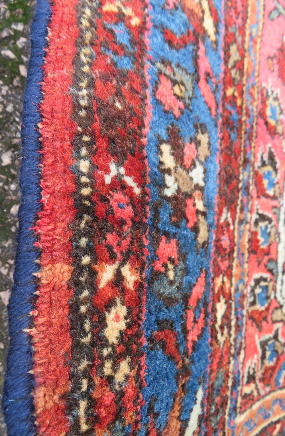 An antique Persian Sarouk hand-knotted wool rug featuring a central floral medallion surrounded by intricate floral vine patterns in rose pink, light blue, navy, and ivory hues. View XII