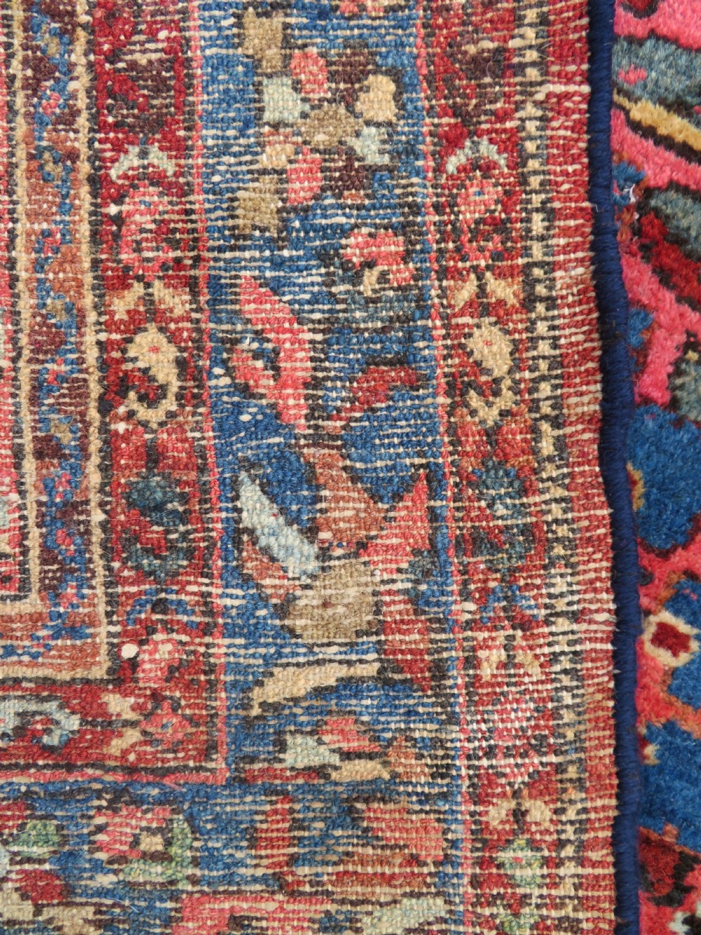 An antique Persian Sarouk hand-knotted wool rug featuring a central floral medallion surrounded by intricate floral vine patterns in rose pink, light blue, navy, and ivory hues. View XIII