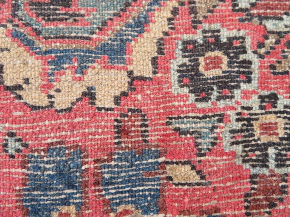 An antique Persian Sarouk hand-knotted wool rug featuring a central floral medallion surrounded by intricate floral vine patterns in rose pink, light blue, navy, and ivory hues. View XXI