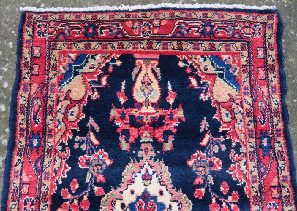 An extra-long antique Persian Sarouk runner rug crafted in wool with navy blue, crimson red, and ivory floral medallion motifs. View IV