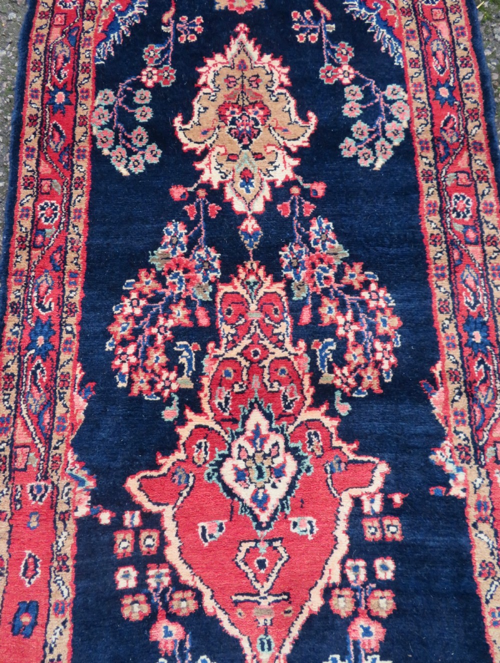 An extra-long antique Persian Sarouk runner rug crafted in wool with navy blue, crimson red, and ivory floral medallion motifs. View V