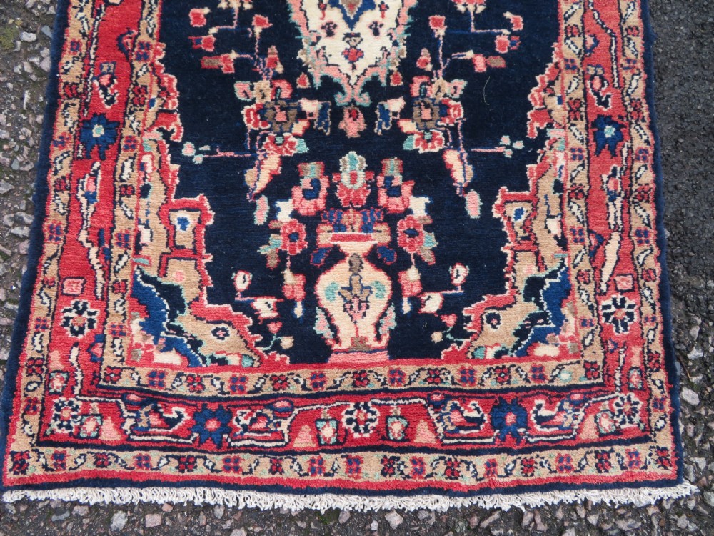 An extra-long antique Persian Sarouk runner rug crafted in wool with navy blue, crimson red, and ivory floral medallion motifs. View VIII