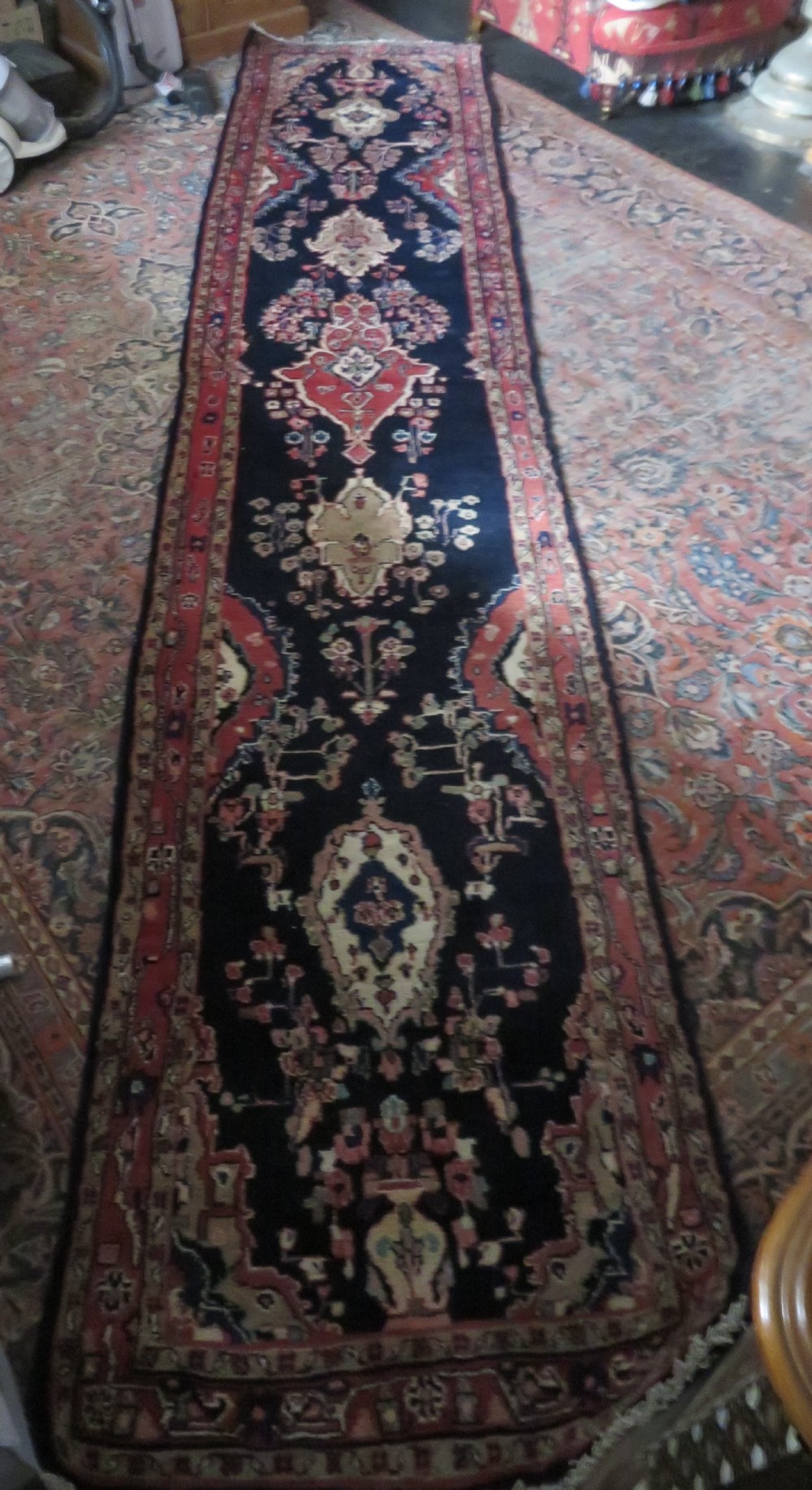 An extra-long antique Persian Sarouk runner rug crafted in wool with navy blue, crimson red, and ivory floral medallion motifs. View XX