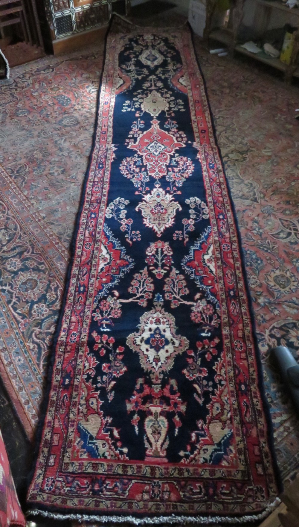 An extra-long antique Persian Sarouk runner rug crafted in wool with navy blue, crimson red, and ivory floral medallion motifs. View XXI