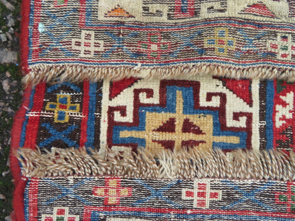 An antique Caucasian Kazak wool runner rug with repeating boteh motifs on a navy blue field framed by geometric multicoloured borders. View XVI