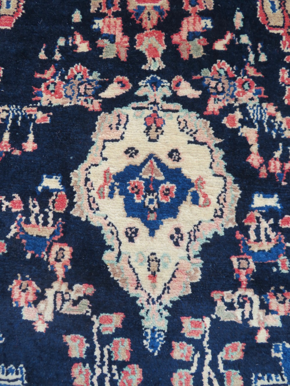 A long, narrow hand-knotted Persian Sarouk runner rug featuring a deep navy blue field, central floral medallions, and terracotta borders. View III