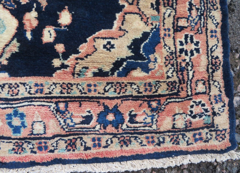 A long, narrow hand-knotted Persian Sarouk runner rug featuring a deep navy blue field, central floral medallions, and terracotta borders. View XI