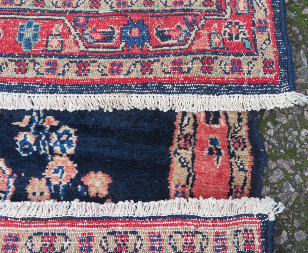 A long, narrow hand-knotted Persian Sarouk runner rug featuring a deep navy blue field, central floral medallions, and terracotta borders. View XIV