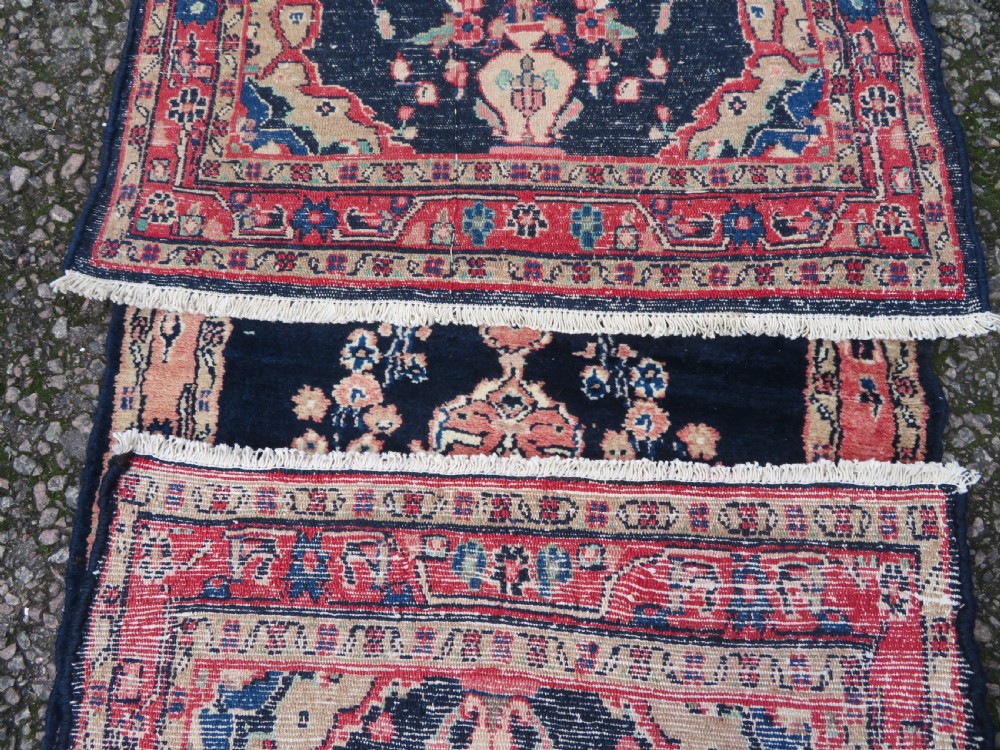 A long, narrow hand-knotted Persian Sarouk runner rug featuring a deep navy blue field, central floral medallions, and terracotta borders. View XV