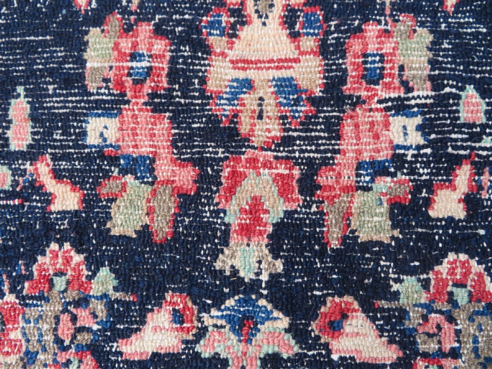 A long, narrow hand-knotted Persian Sarouk runner rug featuring a deep navy blue field, central floral medallions, and terracotta borders. View XVI