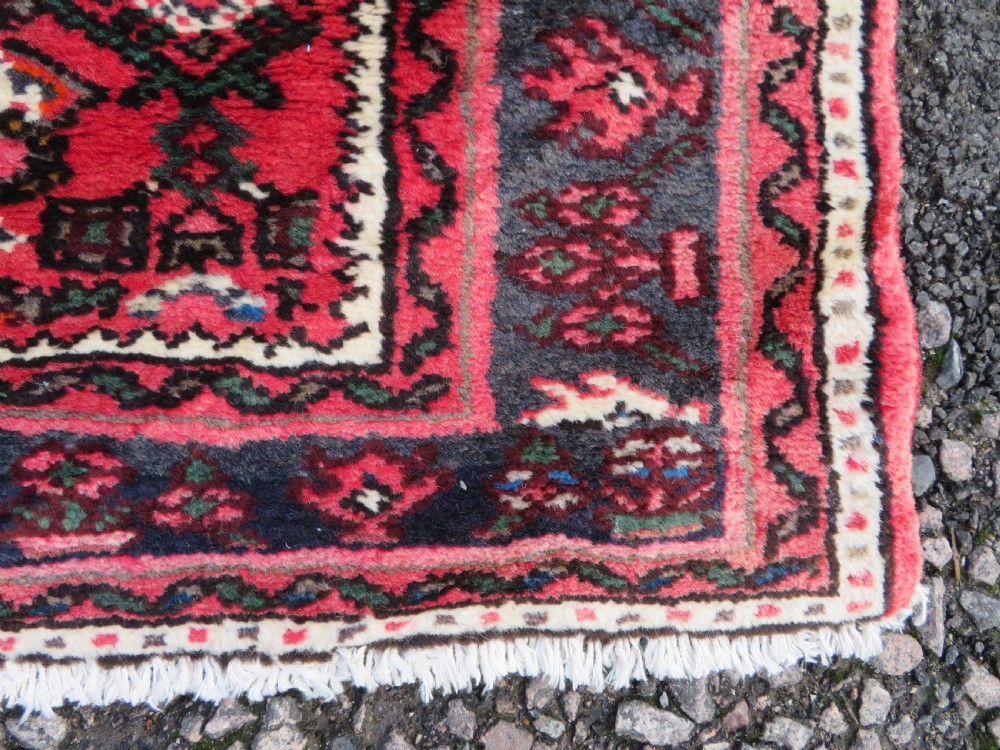 A long, narrow hand-knotted Persian Hamadan runner rug featuring a red field woven with geometric motifs and dark patterned borders. View IX