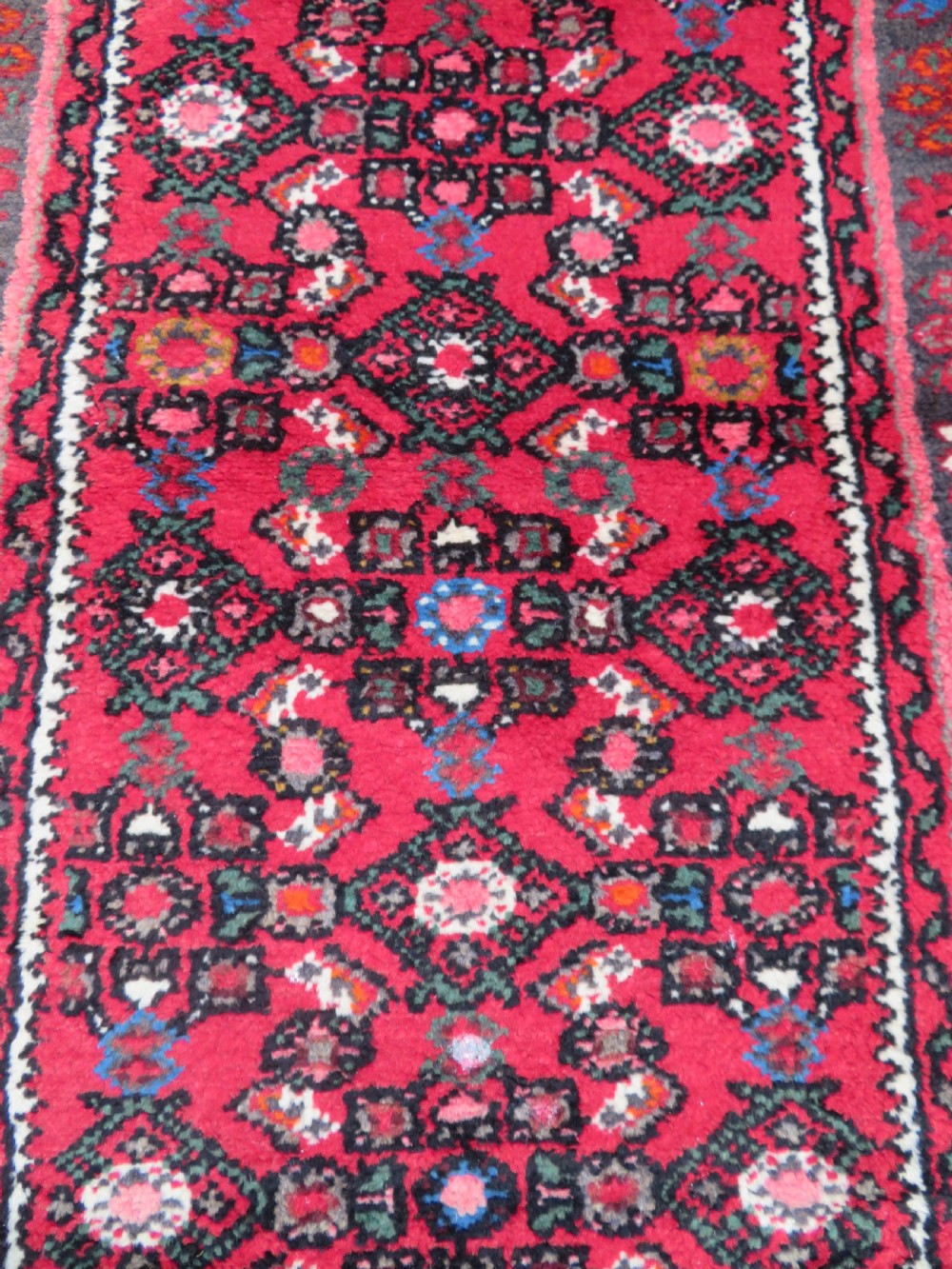 A long, narrow hand-knotted Persian Hamadan runner rug featuring a red field woven with geometric motifs and dark patterned borders. View XIII