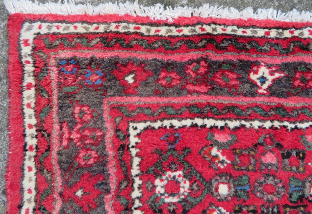 A long, narrow hand-knotted Persian Hamadan runner rug featuring a red field woven with geometric motifs and dark patterned borders. View XIV