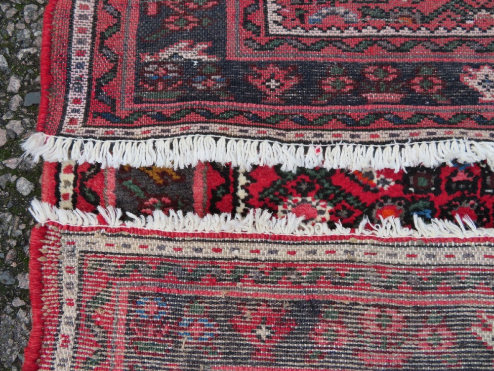 A long, narrow hand-knotted Persian Hamadan runner rug featuring a red field woven with geometric motifs and dark patterned borders. View XVII