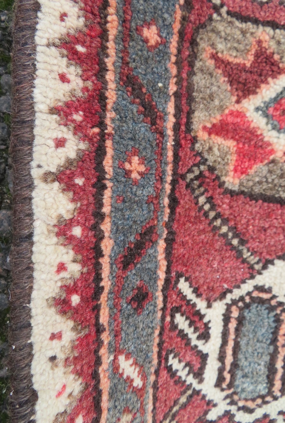 A rectangular hand-knotted North West Persian Kurdish wool rug featuring a central crimson diamond medallion surrounded by geometric motifs on a dark brown field with decorative borders. View XII