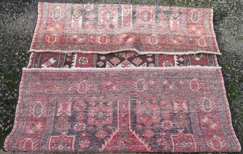 A rectangular hand-knotted North West Persian Kurdish wool rug featuring a central crimson diamond medallion surrounded by geometric motifs on a dark brown field with decorative borders. View XIV