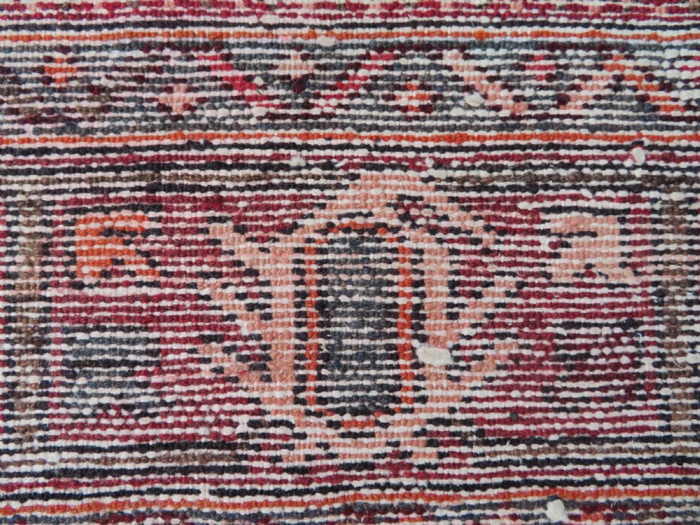 A rectangular hand-knotted North West Persian Kurdish wool rug featuring a central crimson diamond medallion surrounded by geometric motifs on a dark brown field with decorative borders. View XVI
