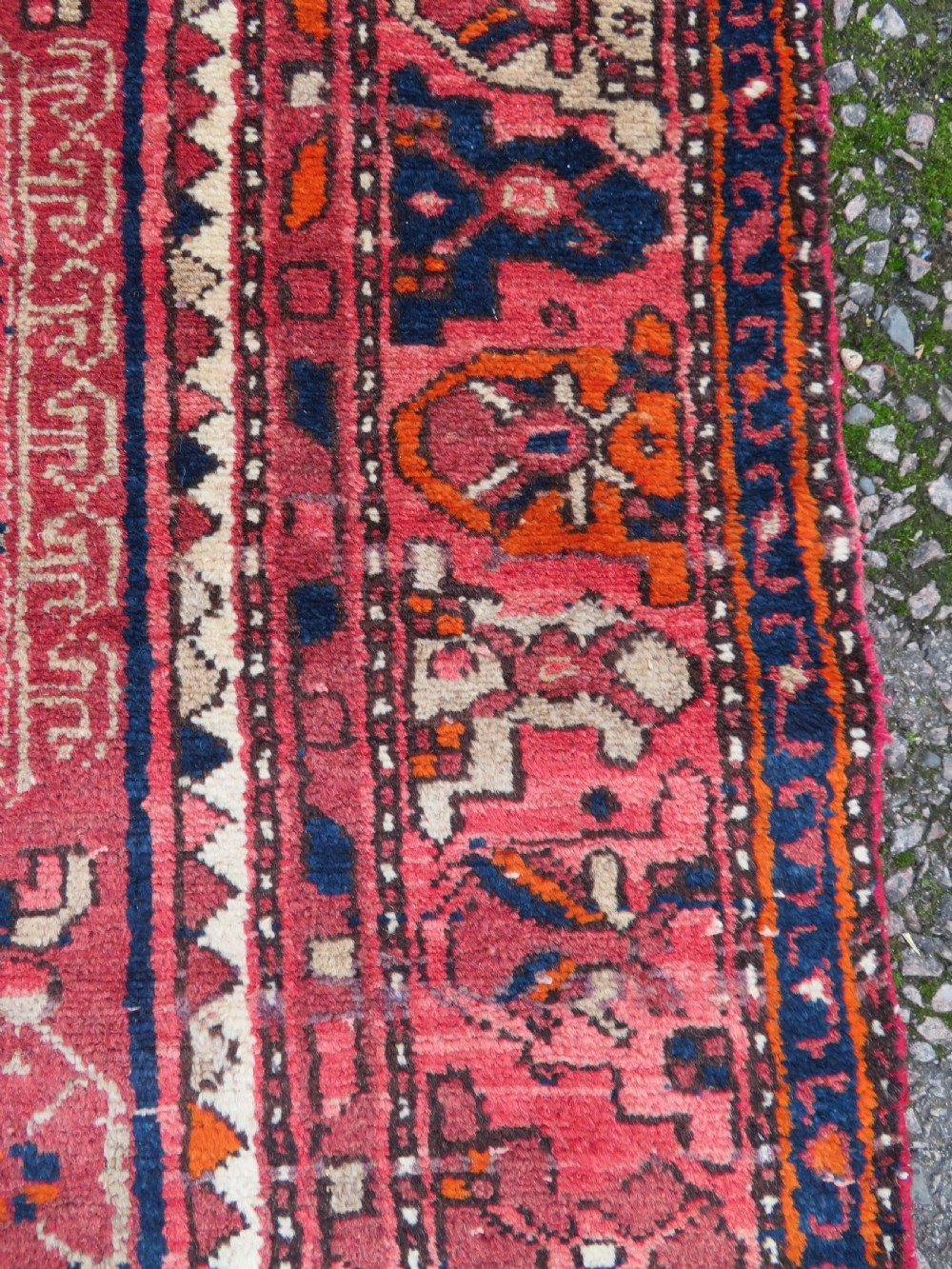 An antique Persian Malayer hand-knotted wool rug featuring a red central field, stepped navy medallion, ivory spandrels, and geometric floral borders. View XII