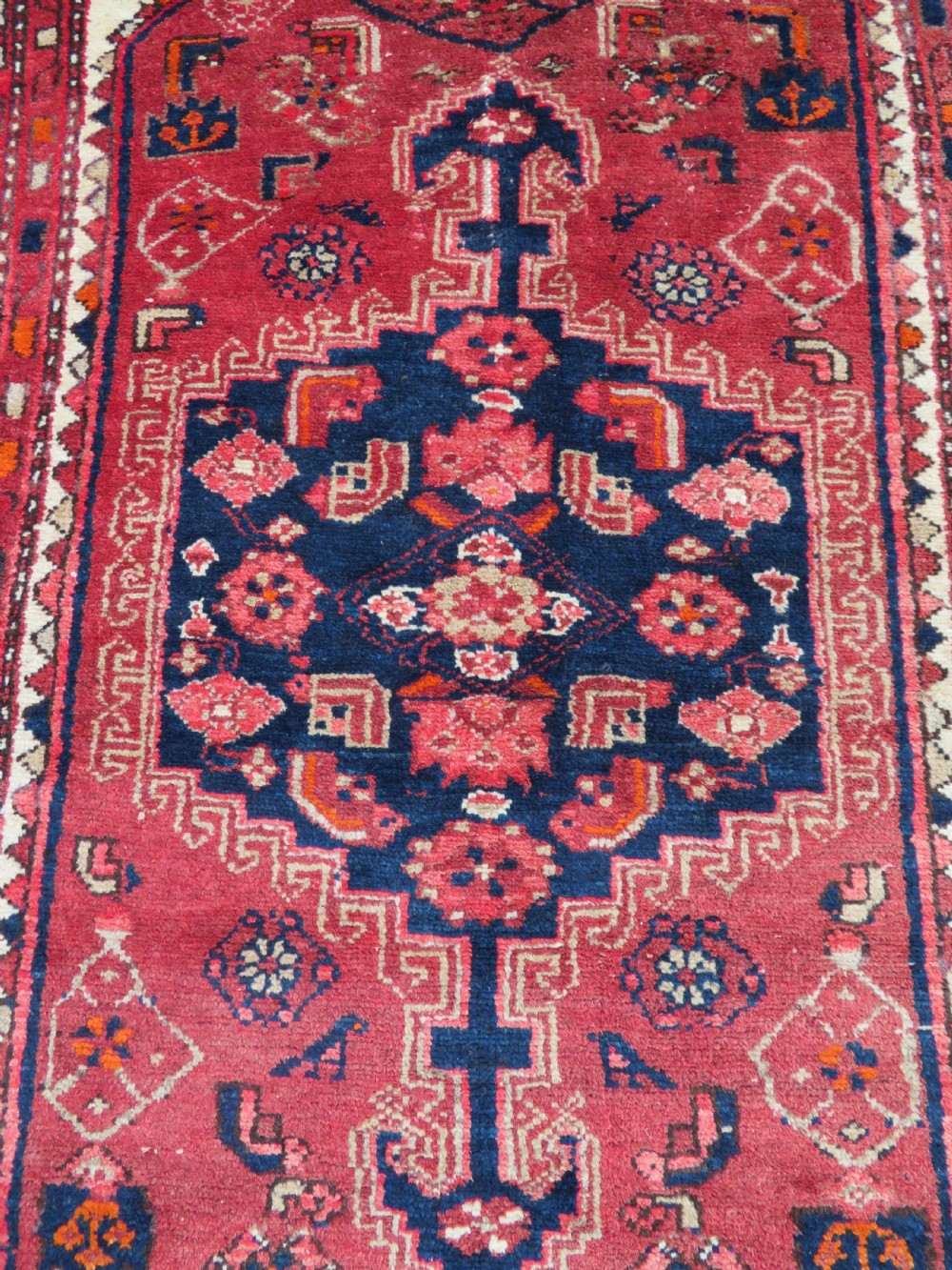 An antique Persian Malayer hand-knotted wool rug featuring a red central field, stepped navy medallion, ivory spandrels, and geometric floral borders. View XIV