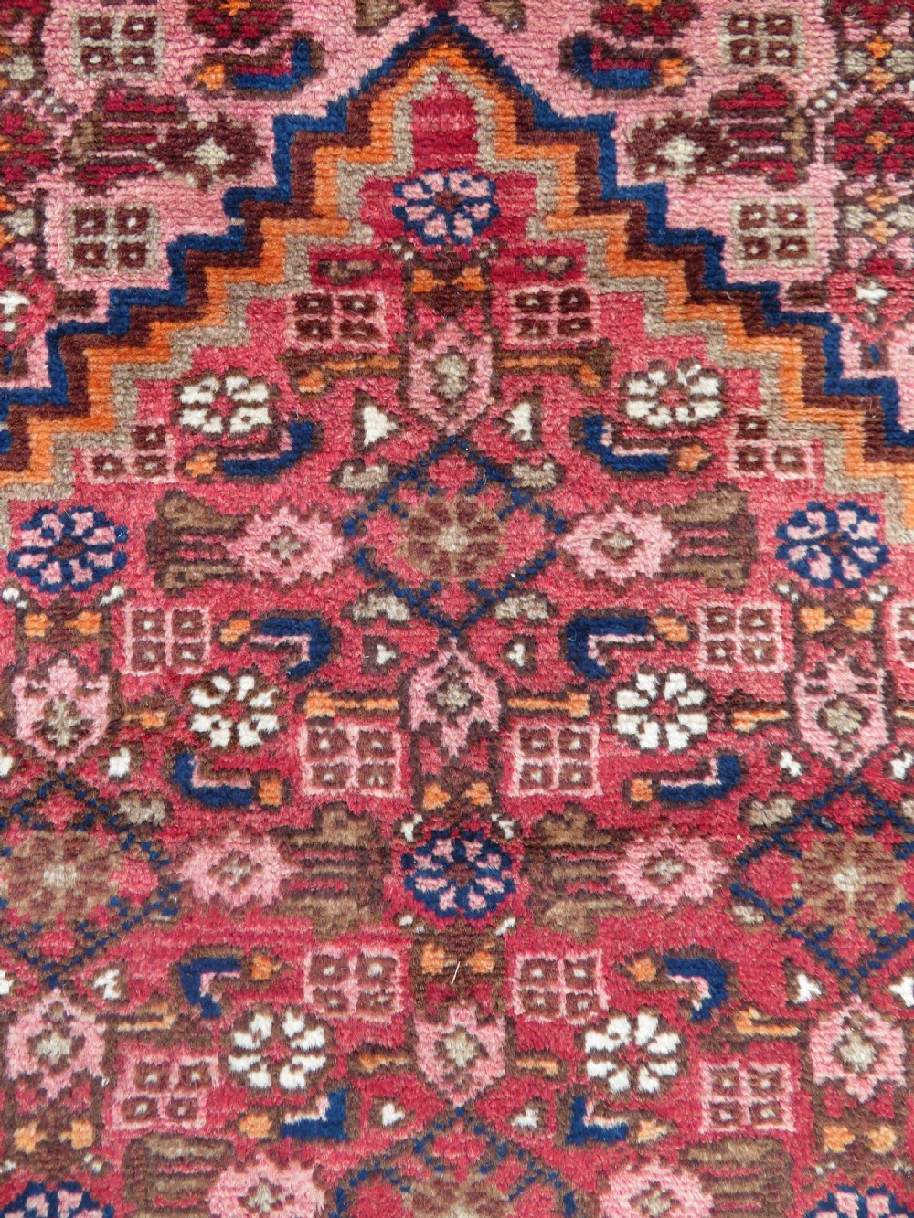 An antique Persian Sanjan Hamadan wool rug runner featuring a central diamond medallion surrounded by geometric motifs in red, cream, and navy blue. View VII