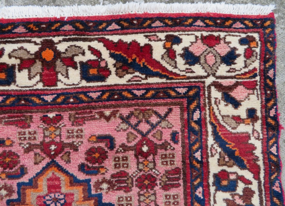 An antique Persian Sanjan Hamadan wool rug runner featuring a central diamond medallion surrounded by geometric motifs in red, cream, and navy blue. View IX