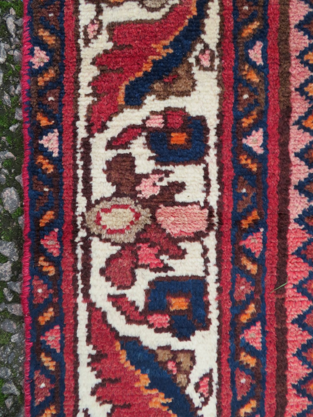An antique Persian Sanjan Hamadan wool rug runner featuring a central diamond medallion surrounded by geometric motifs in red, cream, and navy blue. View X
