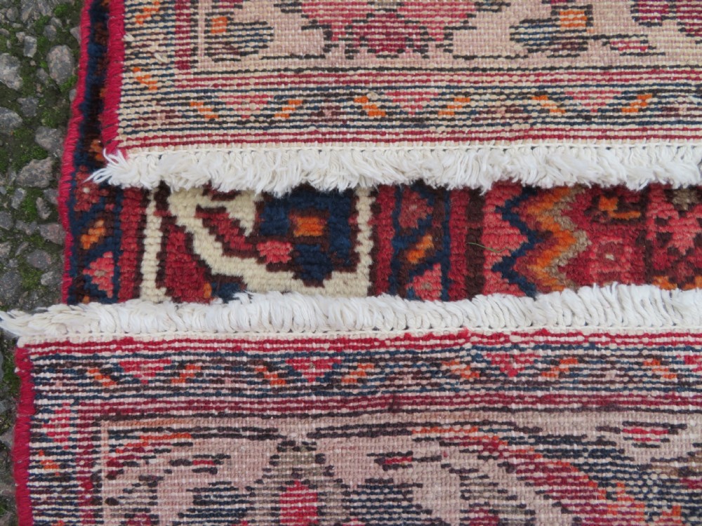An antique Persian Sanjan Hamadan wool rug runner featuring a central diamond medallion surrounded by geometric motifs in red, cream, and navy blue. View XIII