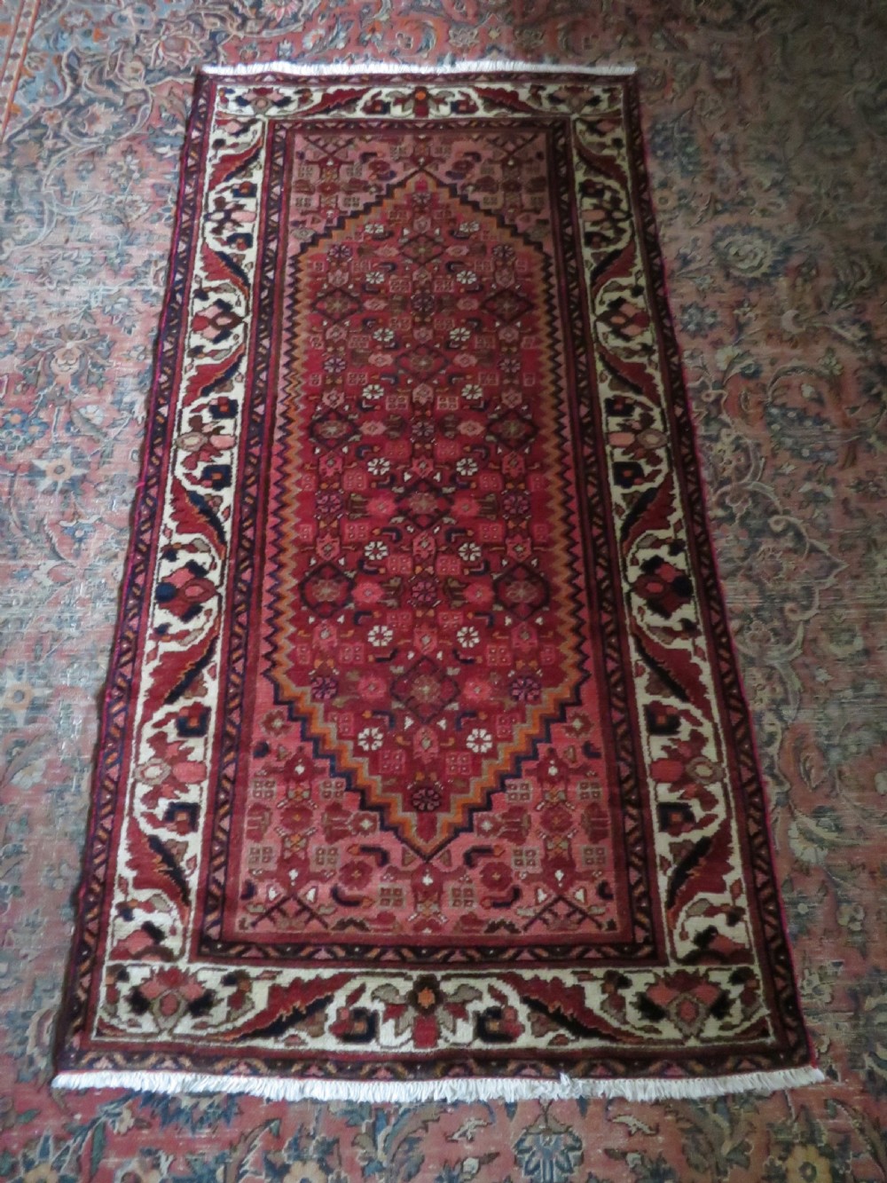 An antique Persian Sanjan Hamadan wool rug runner featuring a central diamond medallion surrounded by geometric motifs in red, cream, and navy blue. View XV