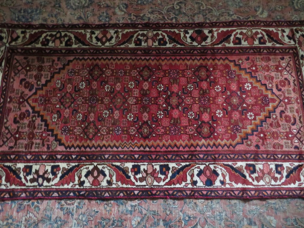 An antique Persian Sanjan Hamadan wool rug runner featuring a central diamond medallion surrounded by geometric motifs in red, cream, and navy blue. View XVI