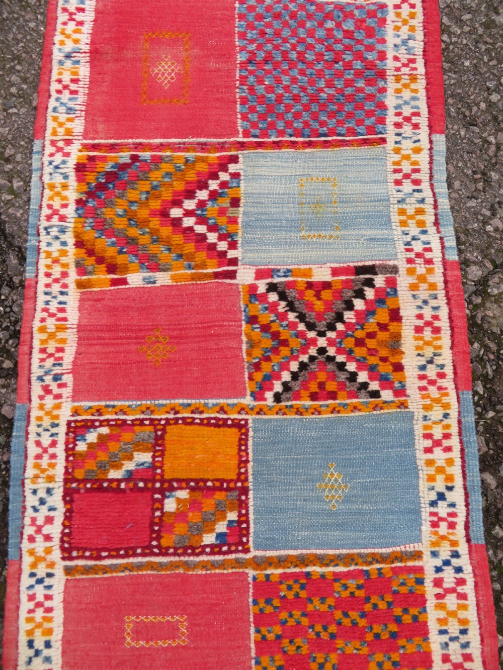 An extra long and narrow handwoven Moroccan Berber runner rug featuring geometric panels in pink, light blue, yellow, and navy with fringed ends. View VIII